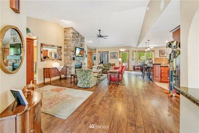 Great room features grand vaulted ceiling, view windows to backyard, cut stone natural gas fireplace, and durable wood laminate floors.