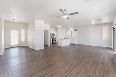 Unfurnished living room with ceiling fan, baseboar