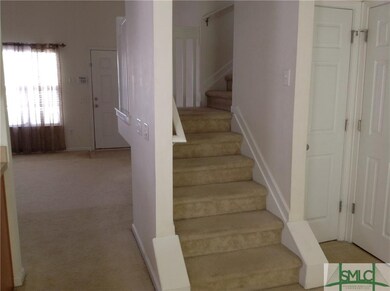 view of living room & stairs from dining area