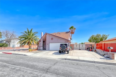 View of side of home with a gate, fence, driveway,
