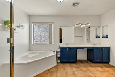 Bathroom featuring double vanity, a garden tub, an