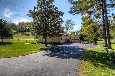 Rear of home with fence, deck and mature trees