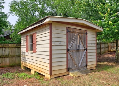 View of shed featuring fence