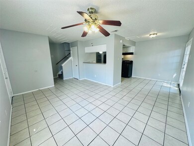 Unfurnished living room with a ceiling fan, a tex