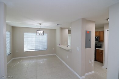 Tiled empty room featuring an inviting chandelier