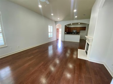 Unfurnished living room with arched walkways, dar