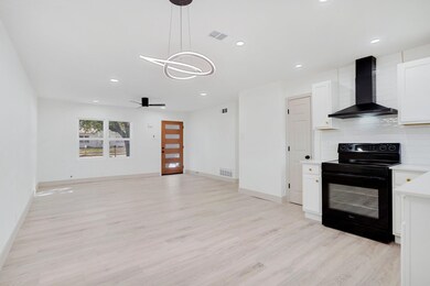 Kitchen featuring visible vents, wall chimney exha