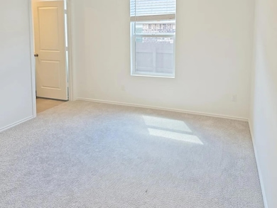Spare room featuring baseboards and carpet floors