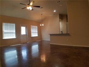 Unfurnished living room featuring lofted ceiling, a ceiling fan, and finished concrete floors