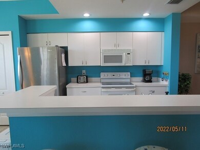Kitchen featuring white appliances, light countert