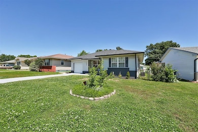 View of front of property featuring an attached garage, driveway, and a front yard
