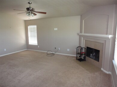 Family room offers corner wood burning fireplace, ceiling fan and traditional mantle