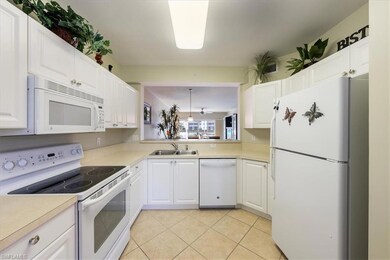 Kitchen with white cabinetry, sink, light tile pat
