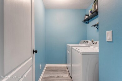 Laundry area with light wood-type flooring and washing machine and clothes dryer