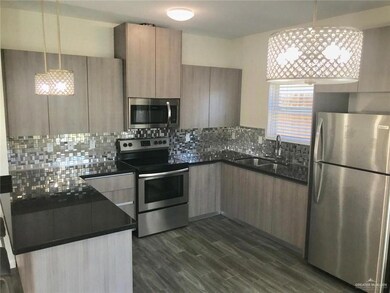 Kitchen featuring appliances with stainless steel finishes, dark countertops, a sink, and modern cabinets