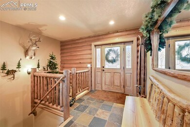 Foyer entrance with a textured ceiling, stone finish flooring, recessed lighting, and log walls