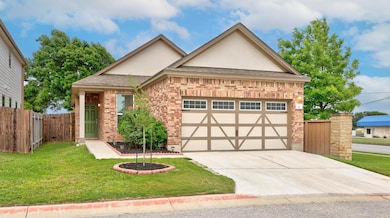 View of front of house featuring fence, brick sid