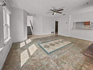 Living room looking at stairs, kitchen, hallway to
