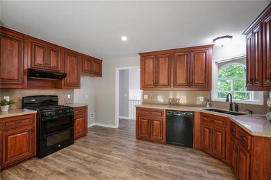Spacious kitchen featuring quality-built cabinetry, durable hard surface countertops, a pantry for extra storage, and easy access to the brand-new back deck—perfect for enjoying the private, wooded backyard.