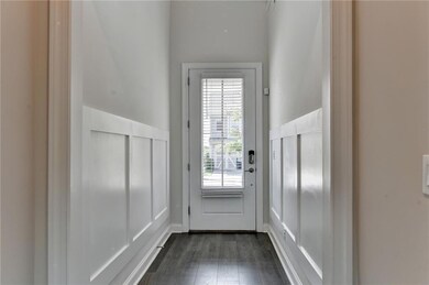 Entryway featuring dark wood-type flooring and wainscoting