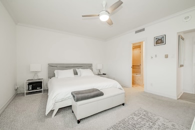 Bedroom with carpet, ornamental molding, and a ceiling fan