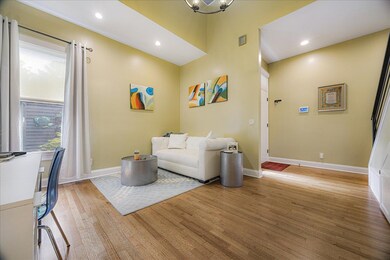 Living room with light wood-style floors, recessed lighting, and a chandelier