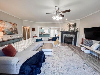 Living room featuring crown molding, ceiling fan, 