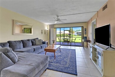 Living room with ceiling fan, and light tile patte
