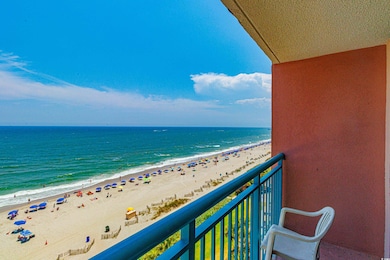 Balcony featuring a beach view and a water view