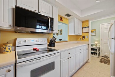 Kitchen with visible vents, white cabinetry, white