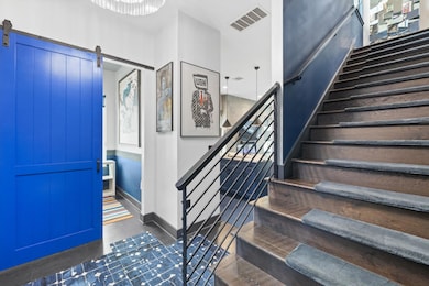 Entryway featuring a barn door, stairs, dark wood