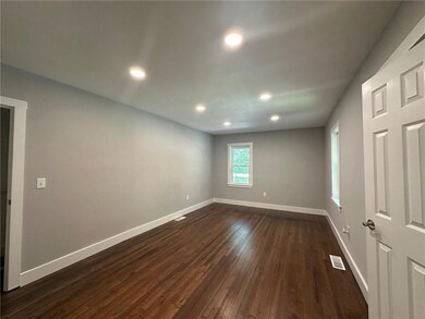 Empty room with dark wood-style floors, baseboards, and recessed lighting