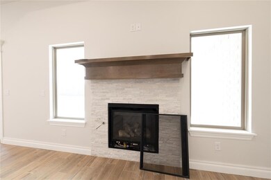 Detailed view of wood finished floors, baseboards, and a fireplace