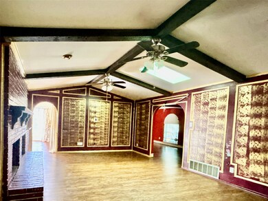 Unfurnished living room with arched walkways, wood finished floors, and a fireplace