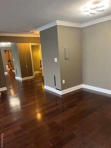 Spare room with ornamental molding and dark wood-style floors