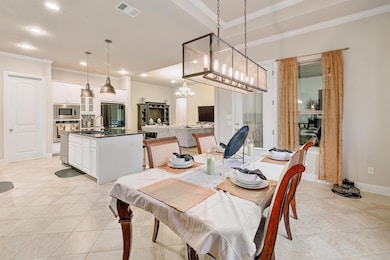Dining room with ornamental molding, light tile patterned floors, recessed lighting, and a chandelier