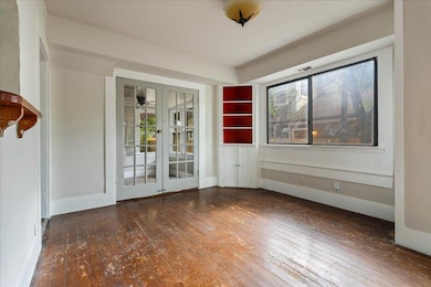 Unfurnished room featuring wood-type flooring, fr