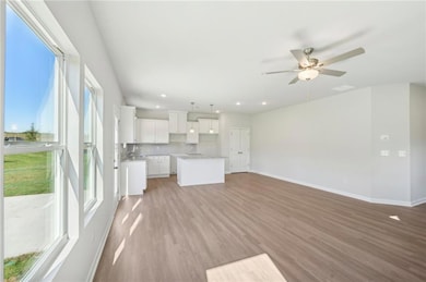 Unfurnished living room featuring a ceiling fan, light wood-style floors, and recessed lighting