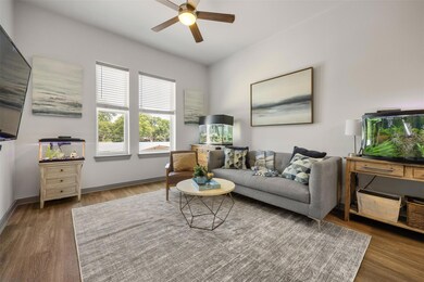 Living area featuring a ceiling fan, wood finishe