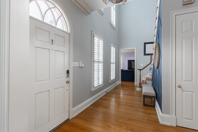Entryway with a towering ceiling, crown molding, a