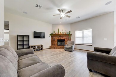 Living room featuring a ceiling fan, light wood-style floors, a fireplace, and baseboards