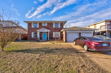 View of front of home with a front yard, a garage,