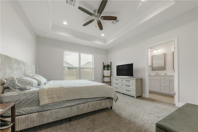 Bedroom with a raised ceiling, connected bathroom,
