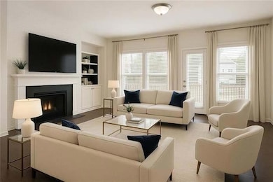 Living room featuring healthy amount of natural light, built in features, and a warm lit fireplace