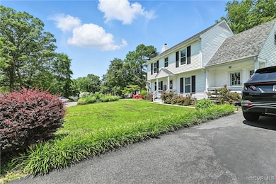 Colonial house with a chimney, a front lawn, and a