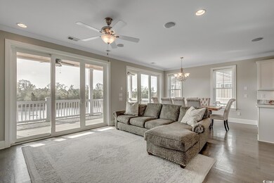 Living room featuring ceiling fan, a chandelier, ornamental molding, wood finished floors, and recessed lighting