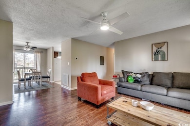 Living room with baseboards, a textured ceiling, w