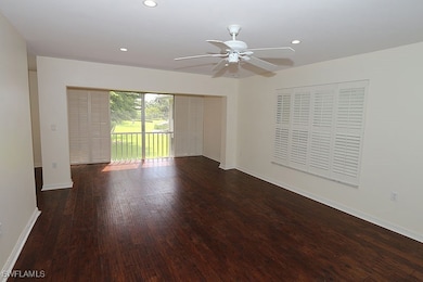 Empty room with dark wood-type flooring and ceiling fan
