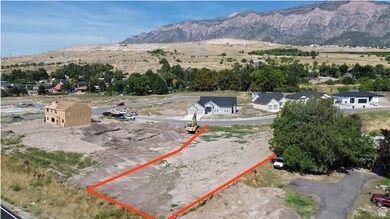 Aerial view of property and surrounding area with a mountain backdrop and property parcel outlined