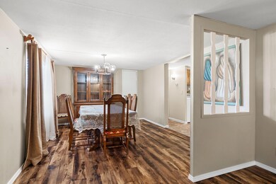 Dining room featuring dark wood-type flooring and a notable chandelier